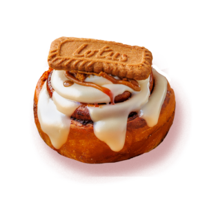 Lotus Biscoff cinnamon roll topped with creamy white icing, caramel drizzle and a Lotus biscuit, isolated on a white background.
